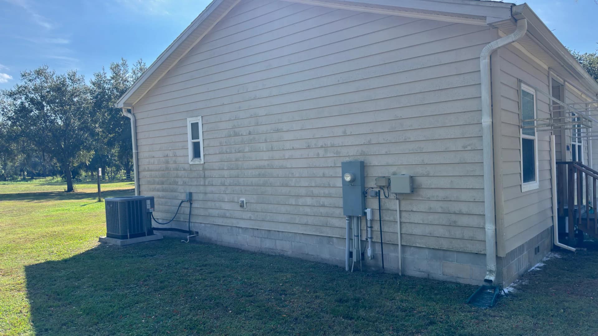 House siding with mildew and weather staining before exterior cleaning for an insurance inspection