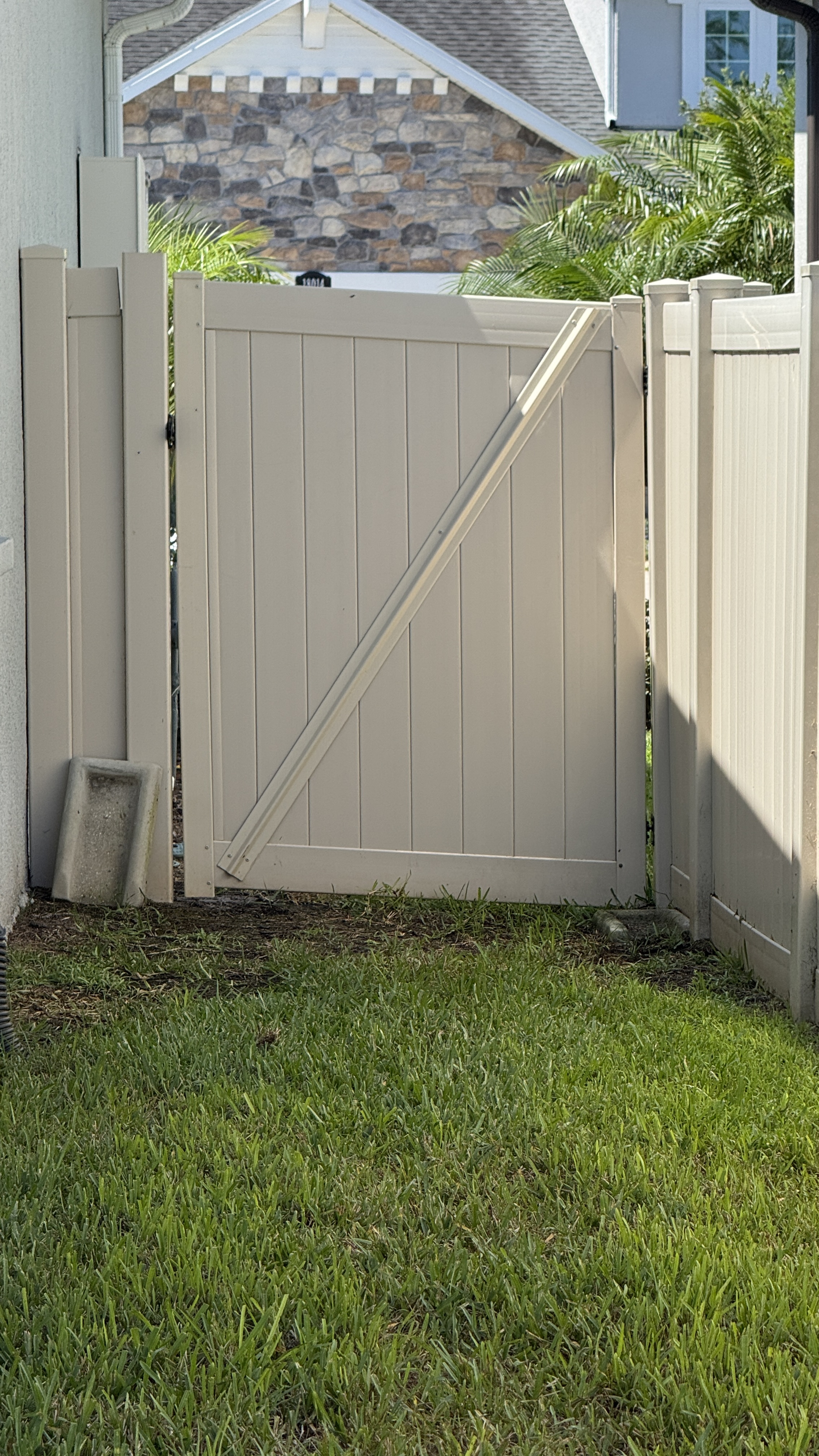 Fence after cleaning in Tampa with a brighter vinyl gate finish