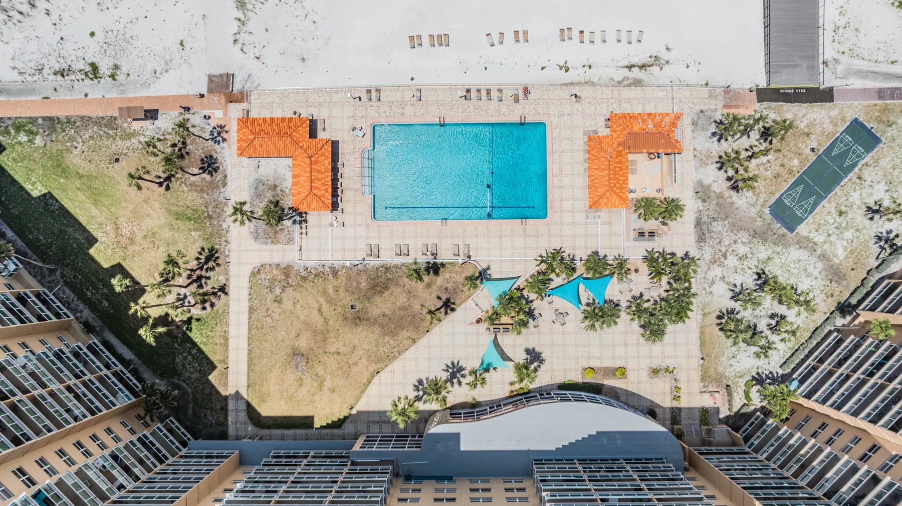 Aerial view of Regatta Beach Club pool and beachfront amenity area after hurricane impacts