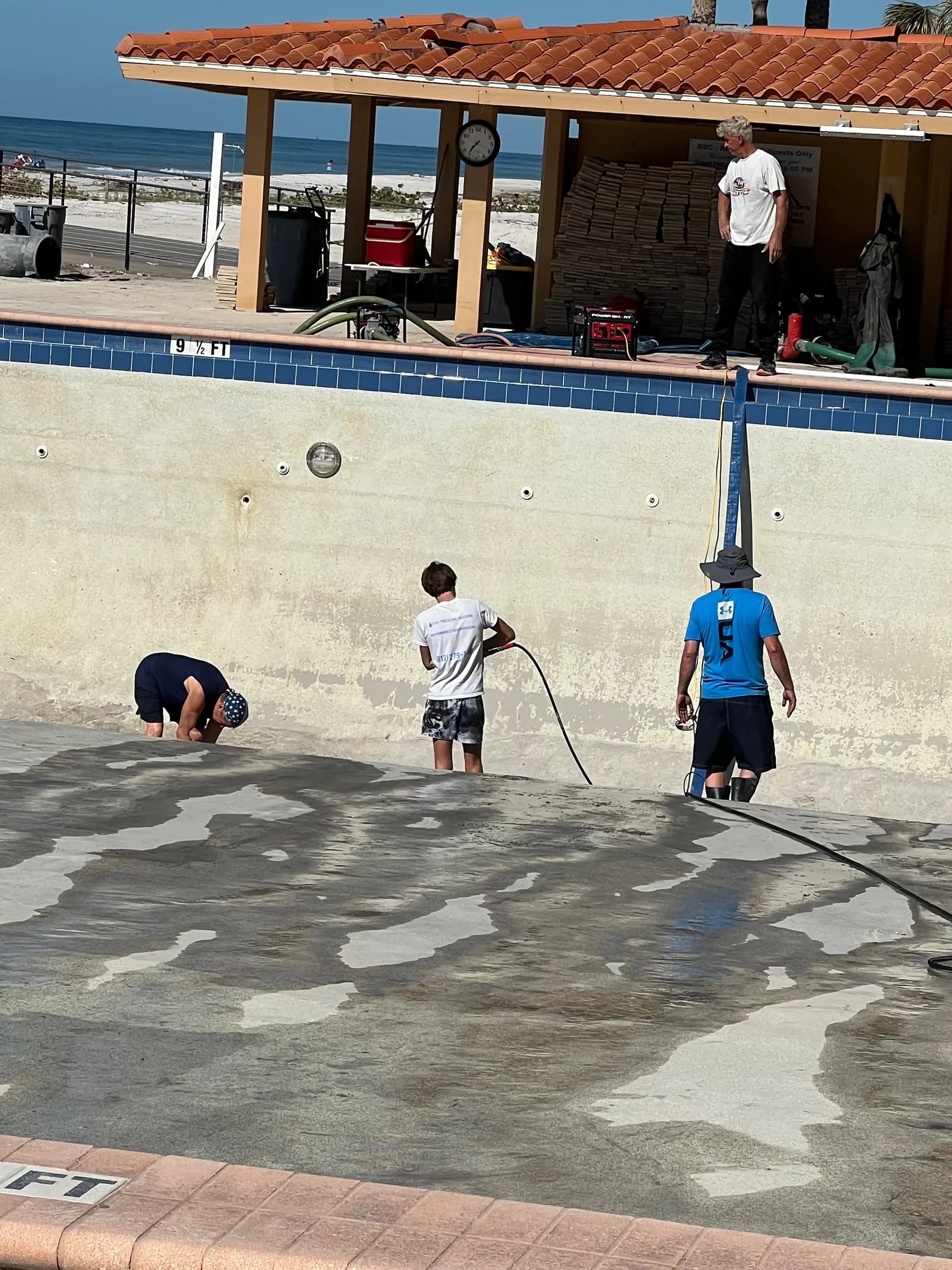 Crew working inside Regatta Beach Club pool during post-hurricane cleanup
