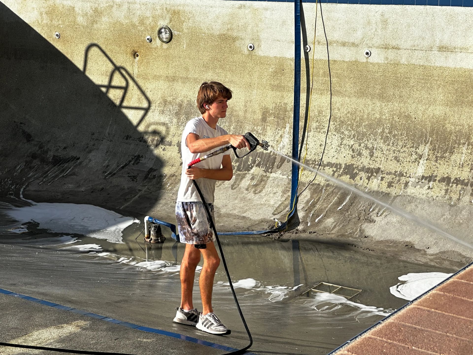 Close-up of pressure washing inside Regatta Beach Club pool area
