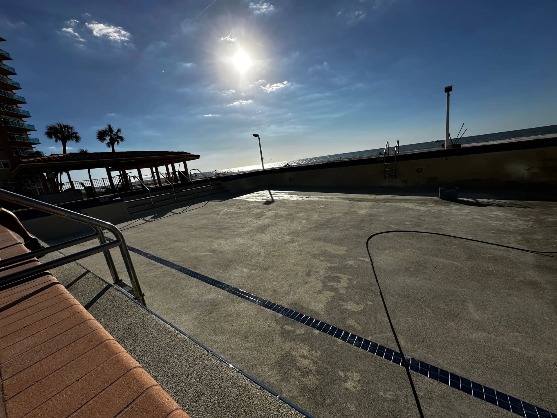 Beachfront drained pool at Regatta Beach Club during cleanup
