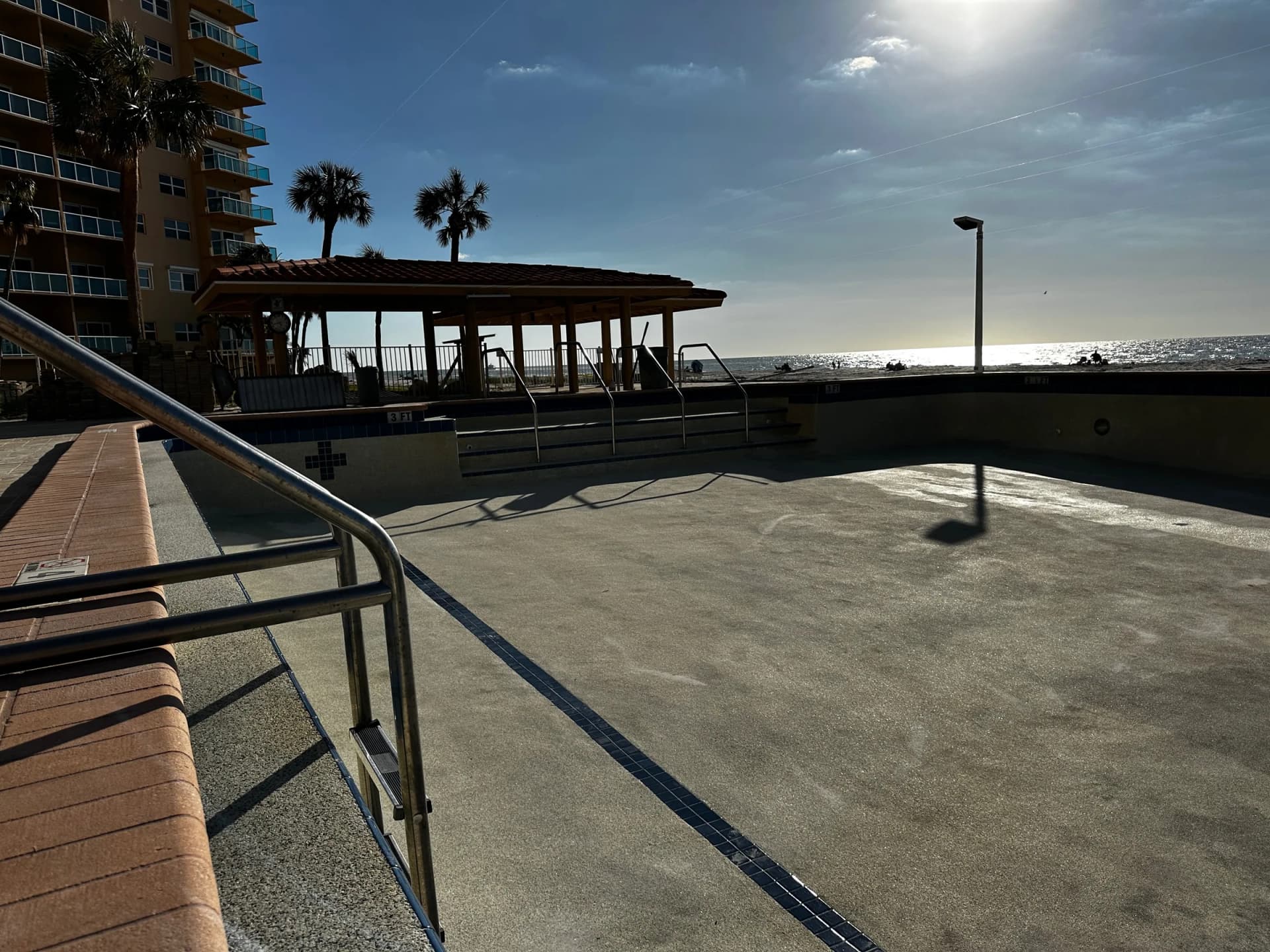Regatta Beach Club drained pool with storm residue and cleanup in progress