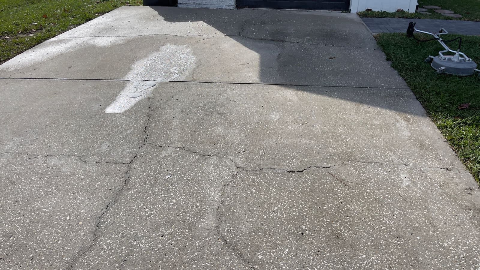 Concrete cleaning example in Tampa showing a cleaned pass across a slab surface