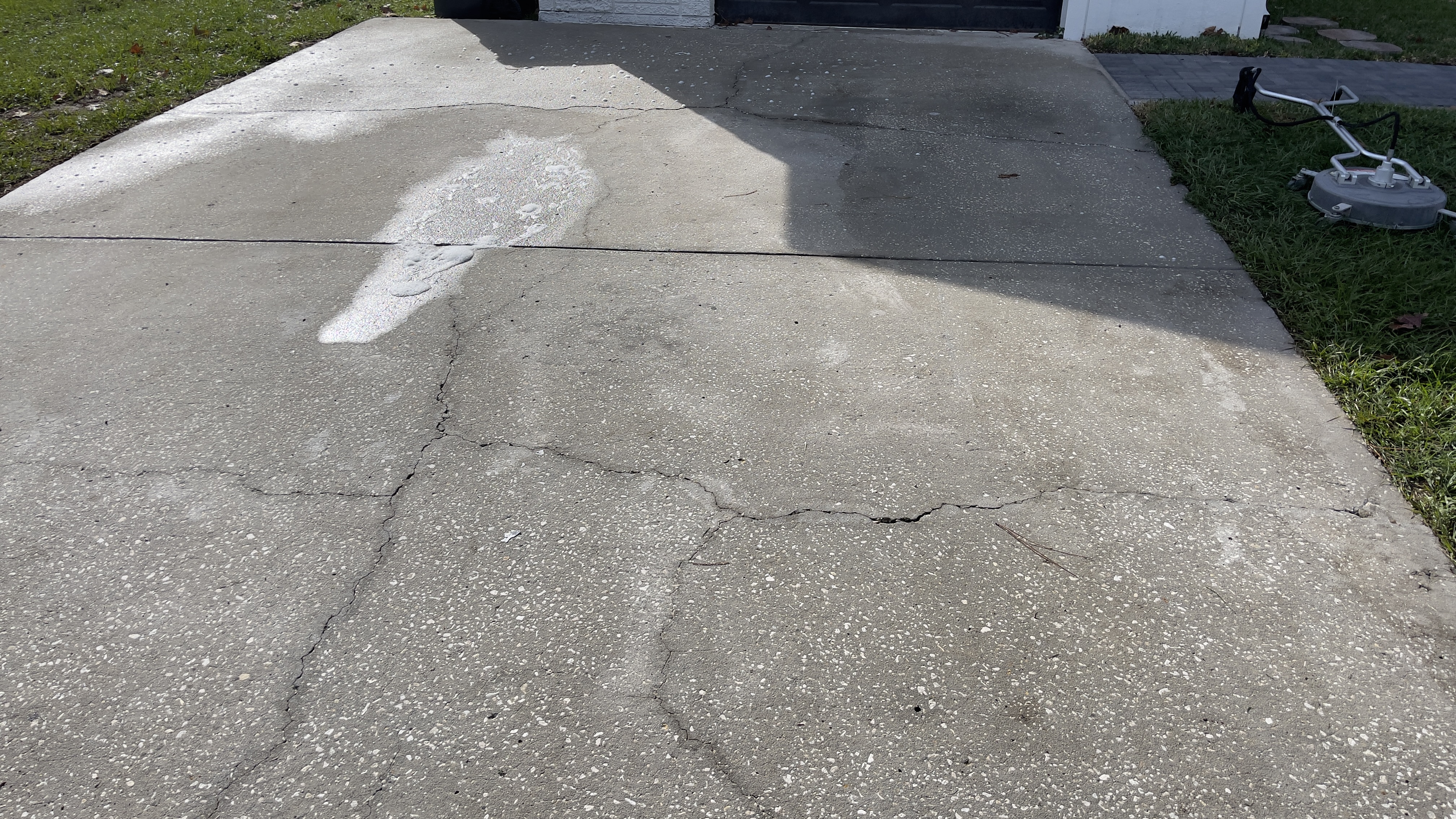 Concrete cleaning example in Tampa showing a cleaned pass across a slab surface