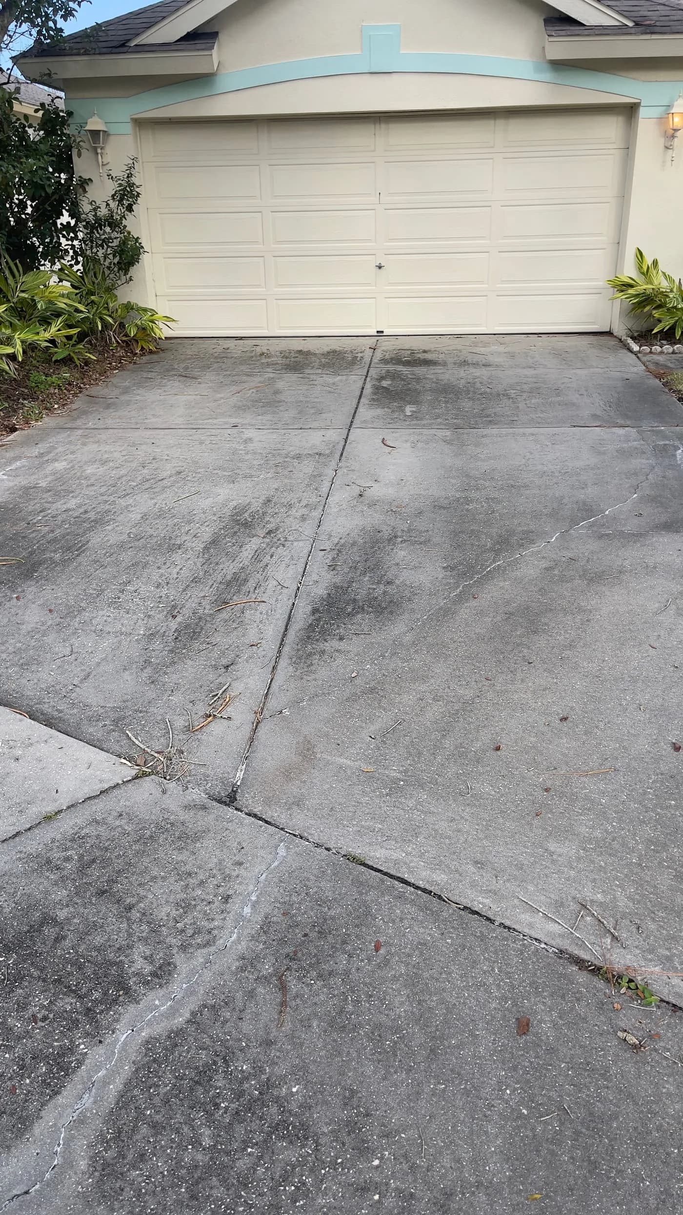 Dirty driveway and garage approach in Tampa with staining that could trigger an HOA warning