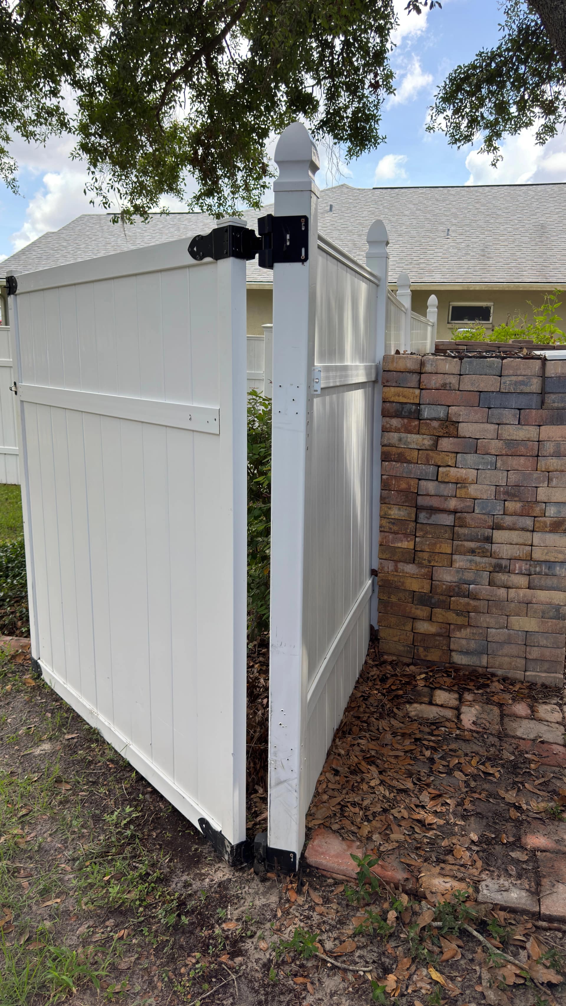 Vinyl fence gate and adjoining fence panels after fence cleaning at a Tampa-area home