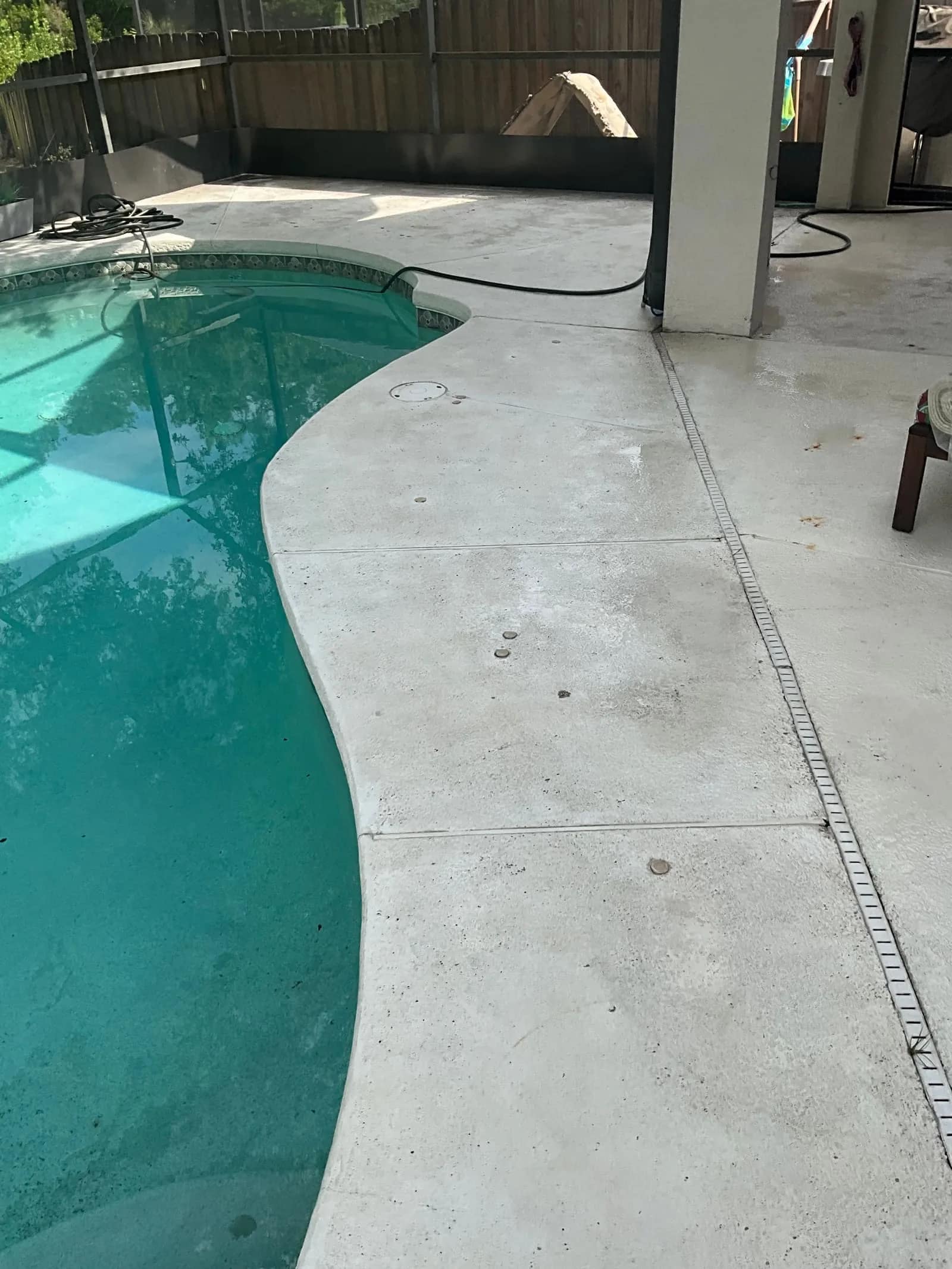 Pool deck cleaning in Tampa with a cleaner concrete surface beside a residential pool